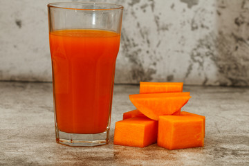 Fresh pumpkin carrot juice on a gray background. Copy space. Place for text.