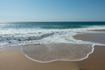 Fototapeta na wymiar Atlantic Ocean at Praia da Areia Branca, Portugal