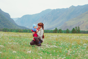 a mother holds a child in her arms in a field