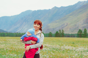 a mother holds a child in her arms in a field