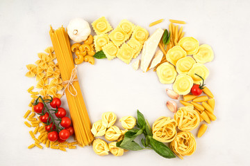 Flat lay with different types of traditional italian pasta. Penne, tagliatelle, fusilli, farfalle, spaghetti and cooking ingredients. Traditional italian cusine concept. Top view