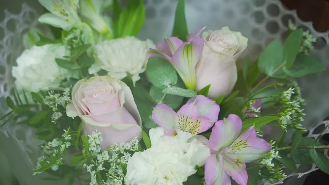 Close-up of a bouquet of fresh of roses and lilies in a flower shop window.