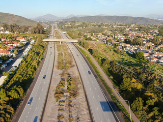 Aerial view of highway surrounded by villa in suburb. Intersection city transport road with vehicle movement. California, USA.