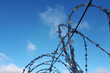 barbed wire against the blue sky