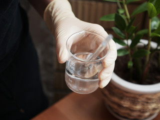 Hands with glass on the table. oncept Creating natural cosmetics at home