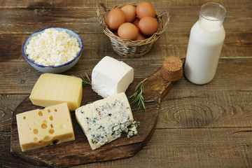assortment of cheese and cottage cheese and bottle of milk and chicken eggs. Organic farm dairy products and eggs.