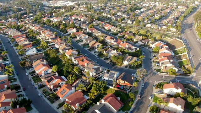 Aerial view of residential modern subdivision house neighborhood with mountain on the background during sunset time. South California, USA
