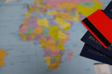 Two passports and bank cards. Against the background of a world map. Silhouettes of continents are visible.
