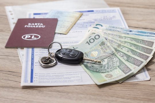 Zakup używanego auta. Karta, dokumenty, pieniądze PLN leżą na stole. 