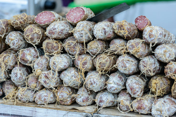 Neatly stacked French dry cured sausages (saucisson sec) on a market stall in Saint-Palais-sur-Mer, Charente-Maritime on the southwestern coast of France