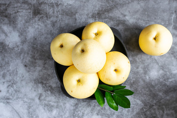 Chinese pears or Asian pears on dark stone table top view. Healthy and or organic food concept.
