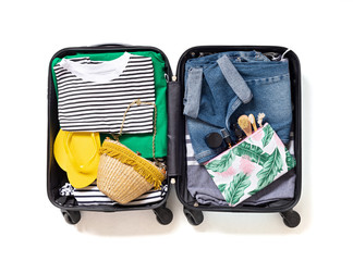 Flat lay with open suitcase with casual clothes for summer vacations over white background. Summer...