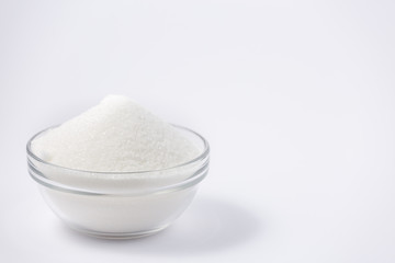 Brown sugar in a round glass cup on a white background, healthy sugar. Used for cooking or desserts.