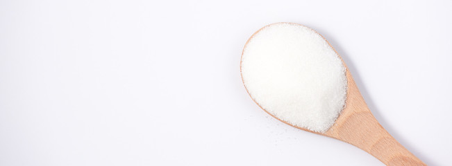 Brown sugar in a wooden spoon on a white background, healthy sugar. Used for cooking or desserts.