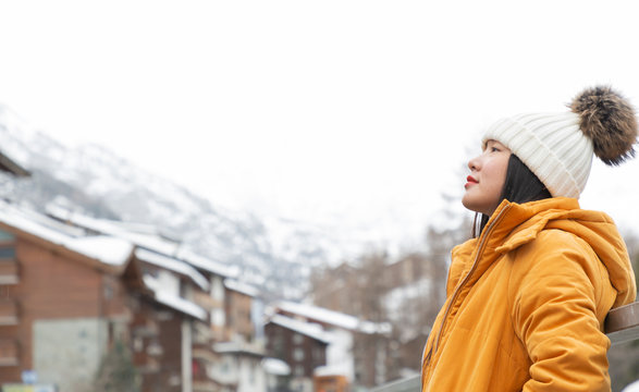 An Asian Woman And Her Family Are Enjoying A Winter Snowy Vacation And Doing Family Activities In Zermatt Matterhorn In Switzerland.