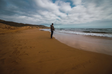 Hombre contemplando las olas del mar en la orilla de la playa
