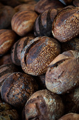large assortment of freshly baked bread at local bakery, stacked loaves, artisan loaf of bread