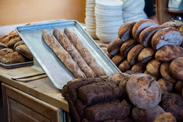 large assortment of freshly baked bread at local bakery, stacked loaves, artisan loaf of bread