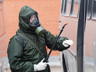 A soldier in a special suit conducts antiviral treatment