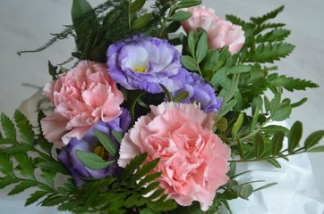 Frühlingshaft pastellfarbiger Blumenstrauß mit rosa Nelken und blauer Glockenblume zum Frauentag