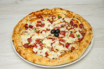 Pizza diavolo traditional italian meal from spicy salami peperoni chili onion olives and basil.
