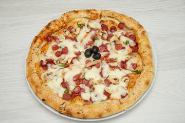 Pizza diavolo traditional italian meal from spicy salami peperoni chili onion olives and basil.