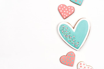 Gingerbread cookies with frosting in the shape of a heart on white background. Flat lay, top view.