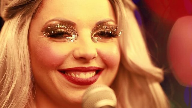 Video clip young woman singer in a New Year costume Snow Maiden sings a song in stage light