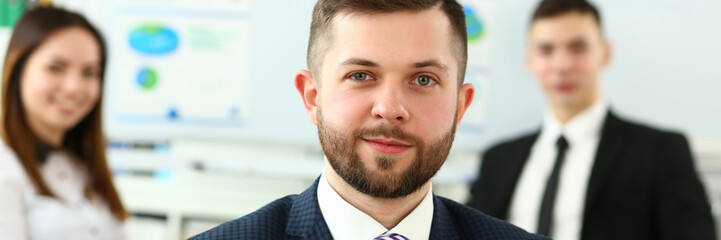 Obraz premium Focus on smart male working in big modern building and discussing important business strategy with younger colleagues and employees. Company meeting concept. Blurred background