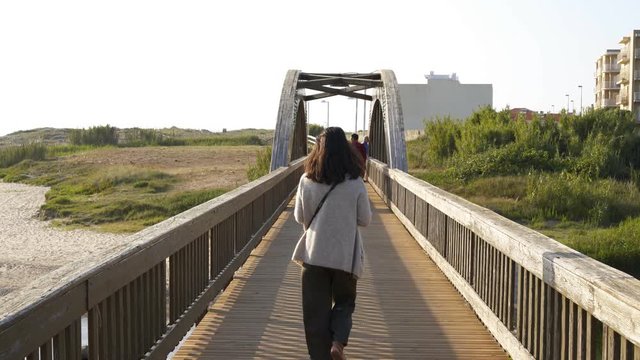 Woman walking on a bridge near Labruge beach, in Portugal