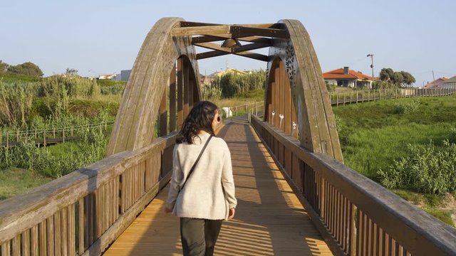 Woman walking on a bridge near Labruge beach, in Portugal