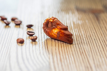 Belgian chocolate shell-shaped on a light wooden background.