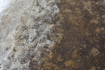 Snow-covered road sprinkled with sand at wintertime.