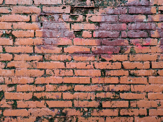 Painted brick wall of an architectural structure in red. Fashionable texture.