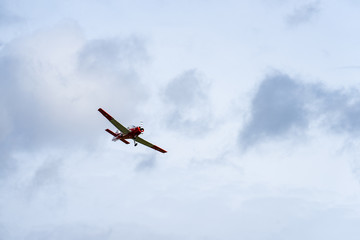 Fototapeta na wymiar Small single engine airplane flying in the english cloudy sky