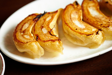 Pan fried dumpling on white plate