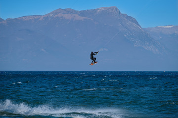 kitesurfer in the jump on a background of high mountains