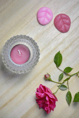 Flat lay of pink flower, tea light and wax melts