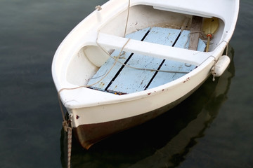 Small white fishing boat in a shallow sea. Selective focus.