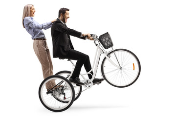Obraz premium Man riding a woman on a tricycle with front wheel up