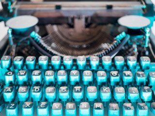 Old vintage typewriter, retro machine with white sheet of paper and typed text.