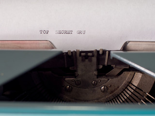 close-up typing TOP SECRET, old vintage typewriter with sheet of paper. Blood splatter. concept of bloody secrets