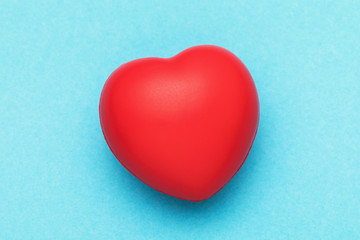 Red toy heart on a blue background, top view