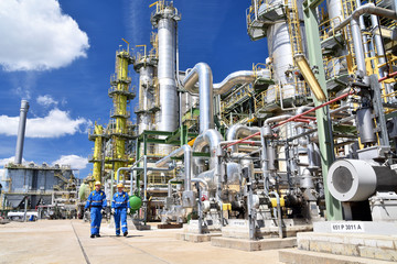 chemical industry plant - workers in work clothes in a refinery with pipes and machinery - 326495250