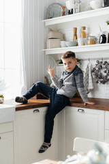 A boy plays and has breakfast in the kitchen. Happiness. A family.