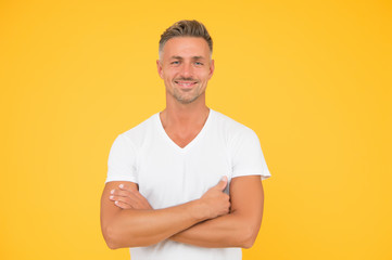 Confident and optimistic. Confident man with crossed arms yellow background. Happy guy smile with confidence. Confident look of fashion model. Casual style. Mens wardrobe. Confident and happy
