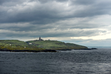 Fototapeta na wymiar Lighthouse on small island at sea in Scotland, United Kingdom.