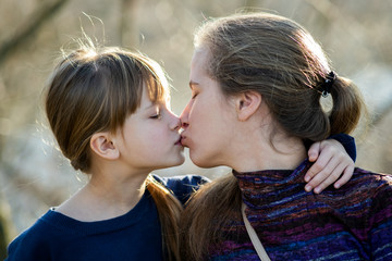 Young mom and her daughter girl together outdoors.