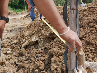 A measuring tape being used to check the length of land during a survey