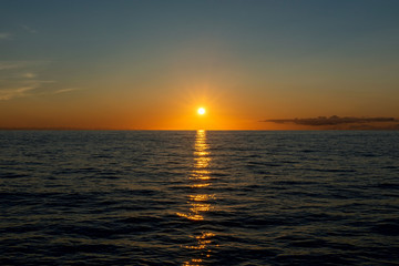 Beautiful sunset on sky with clouds at sea